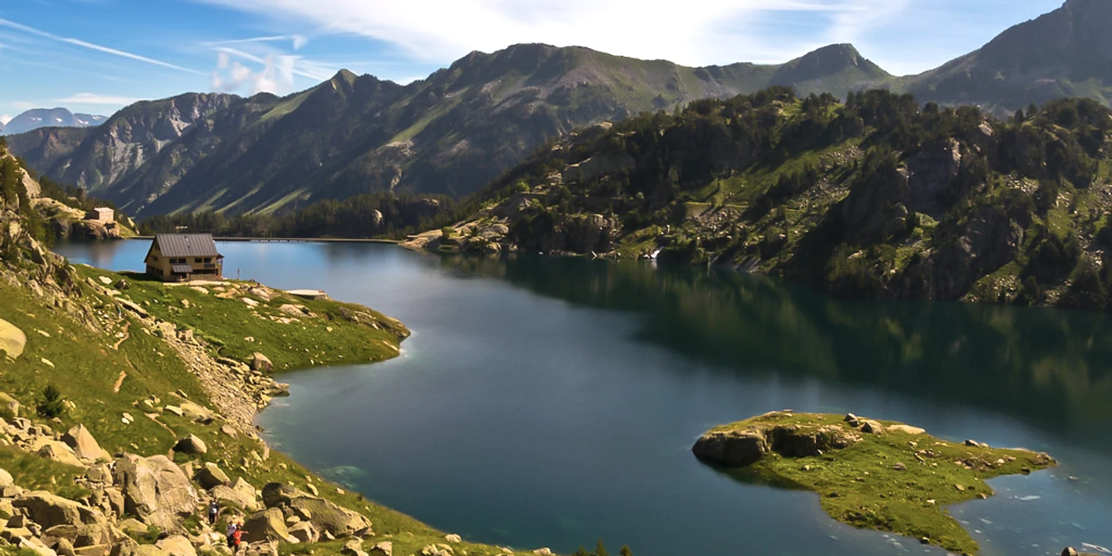 Refugio de Colomèrs junto al lago, con las montañas al fondo